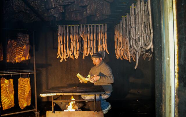 Peter Vergeiner beim Einheizen des Holzfeuers in der Selchkammer des Untermaierhofs